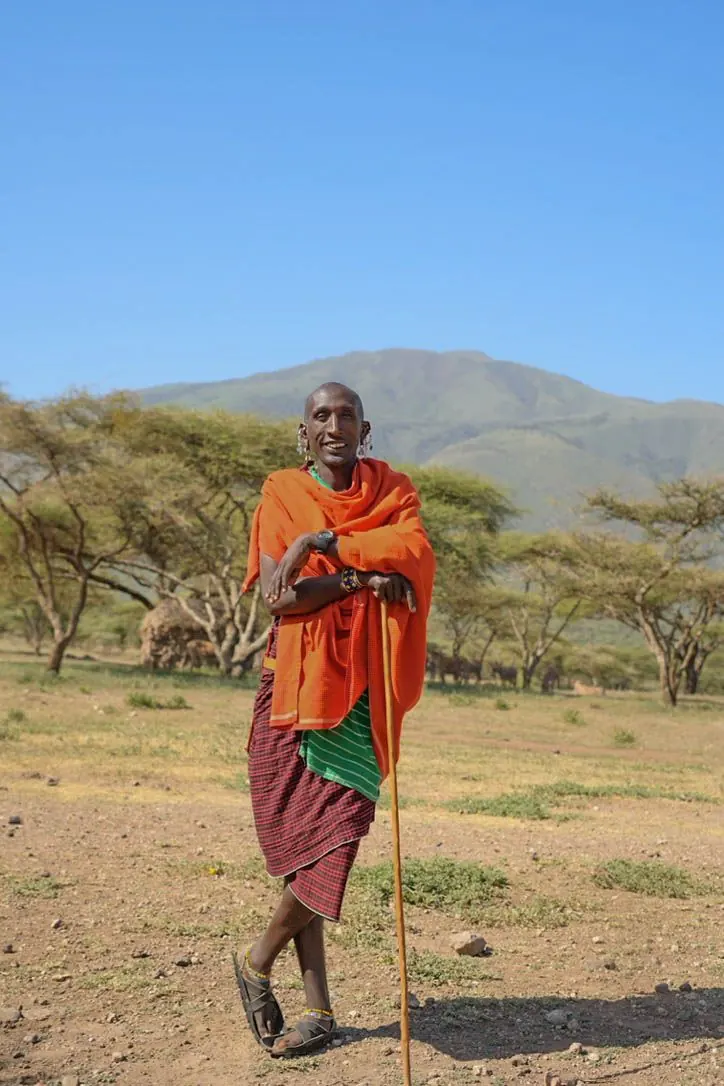 Hombre masái sonriendo ante acacias y las tierras altas del Ngorongoro